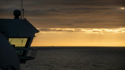 a ship is silhouetted against the sunset