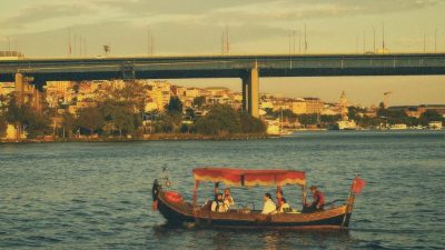 a boat is floating on the water under a bridge