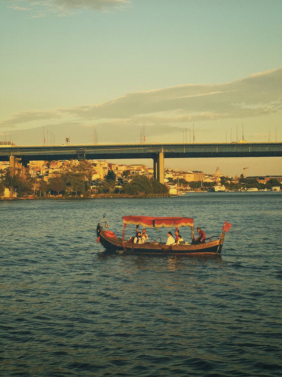 a boat is floating on the water under a bridge