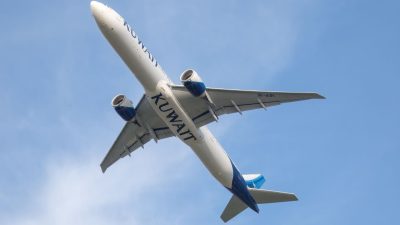 kuwait airways plane mid flight against blue sky