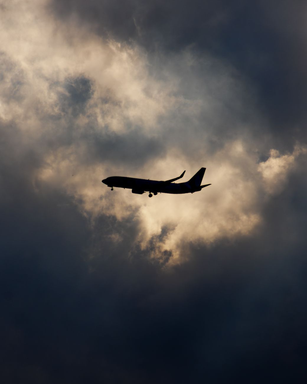 airplane silhouette in dramatic cloudy sky