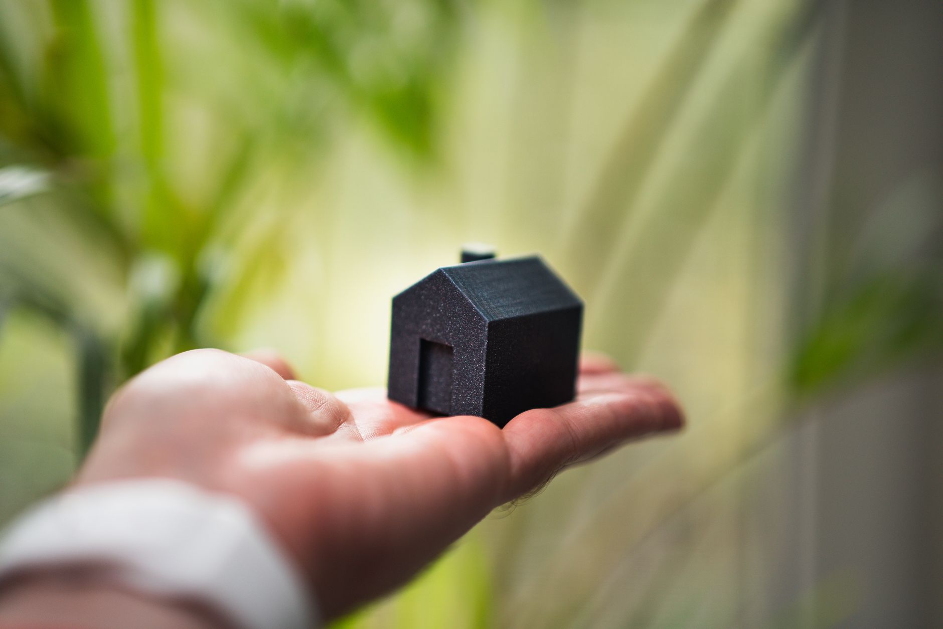 miniature house model in open hand outdoors