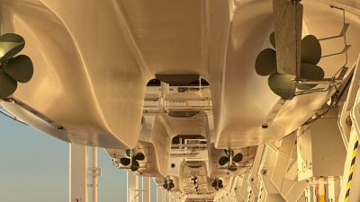 sunlit cruise ship deck with lifeboats