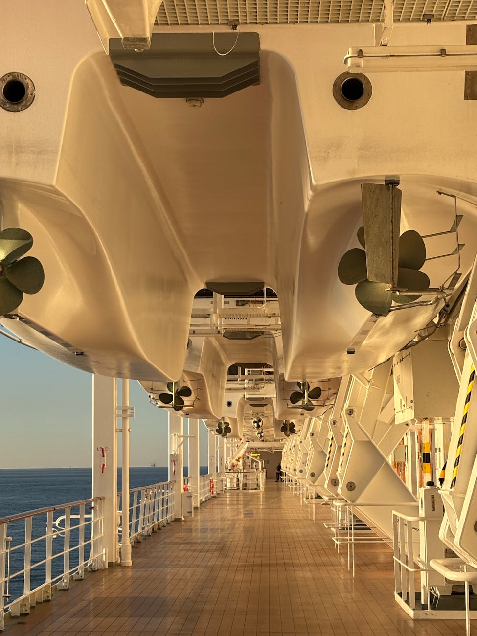 sunlit cruise ship deck with lifeboats