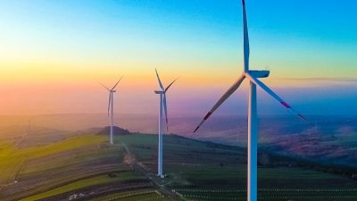 wind turbines at sunset over rolling hills