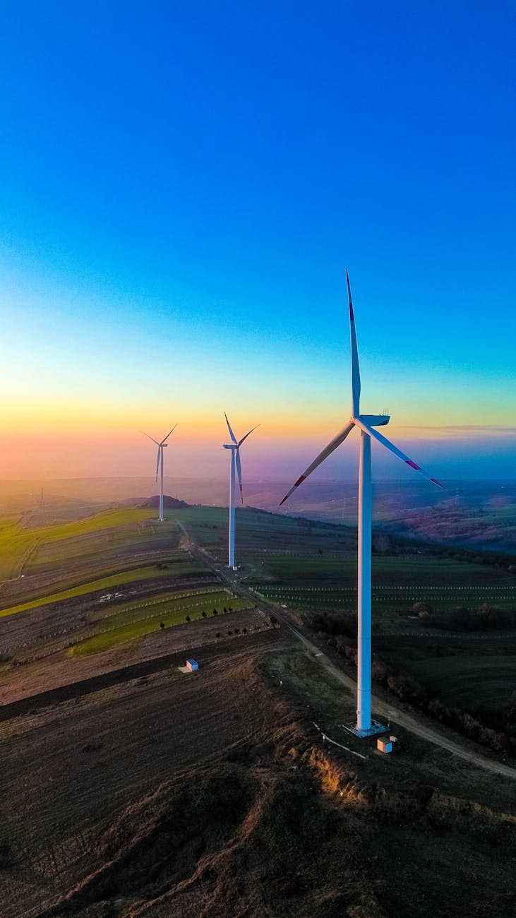 wind turbines at sunset over rolling hills