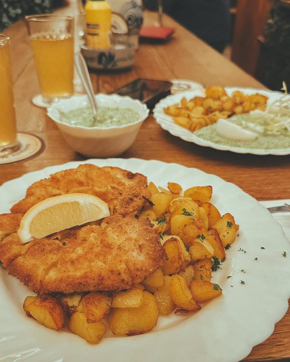 crispy schnitzel with potatoes on wooden table
