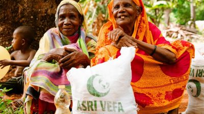 elderly women smiling with food aid outdoors