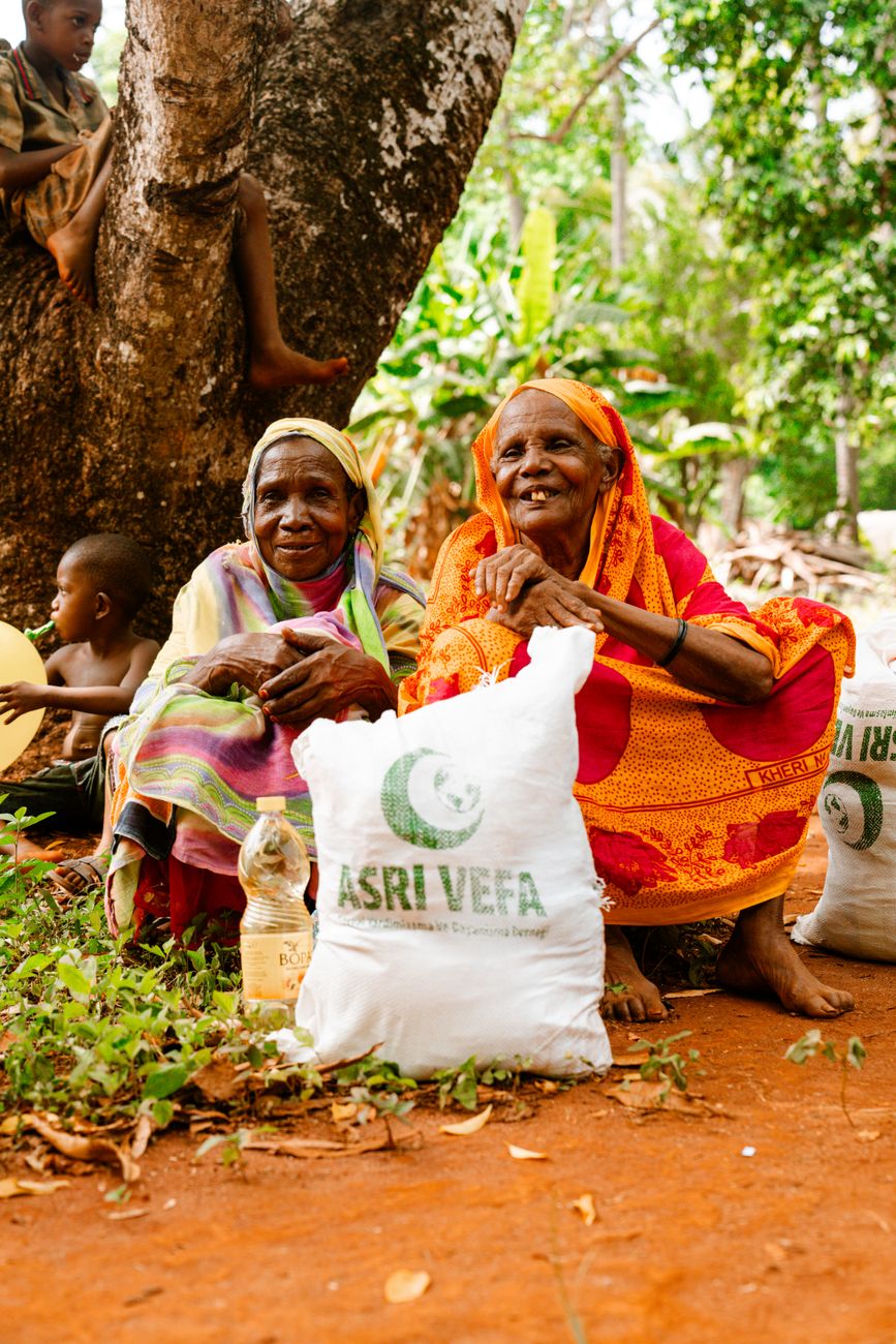 elderly women smiling with food aid outdoors