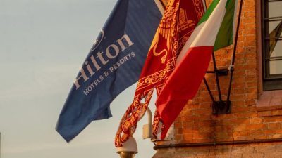 flags flying at historic venetian building at sunset