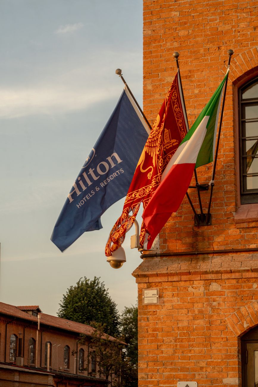 flags flying at historic venetian building at sunset