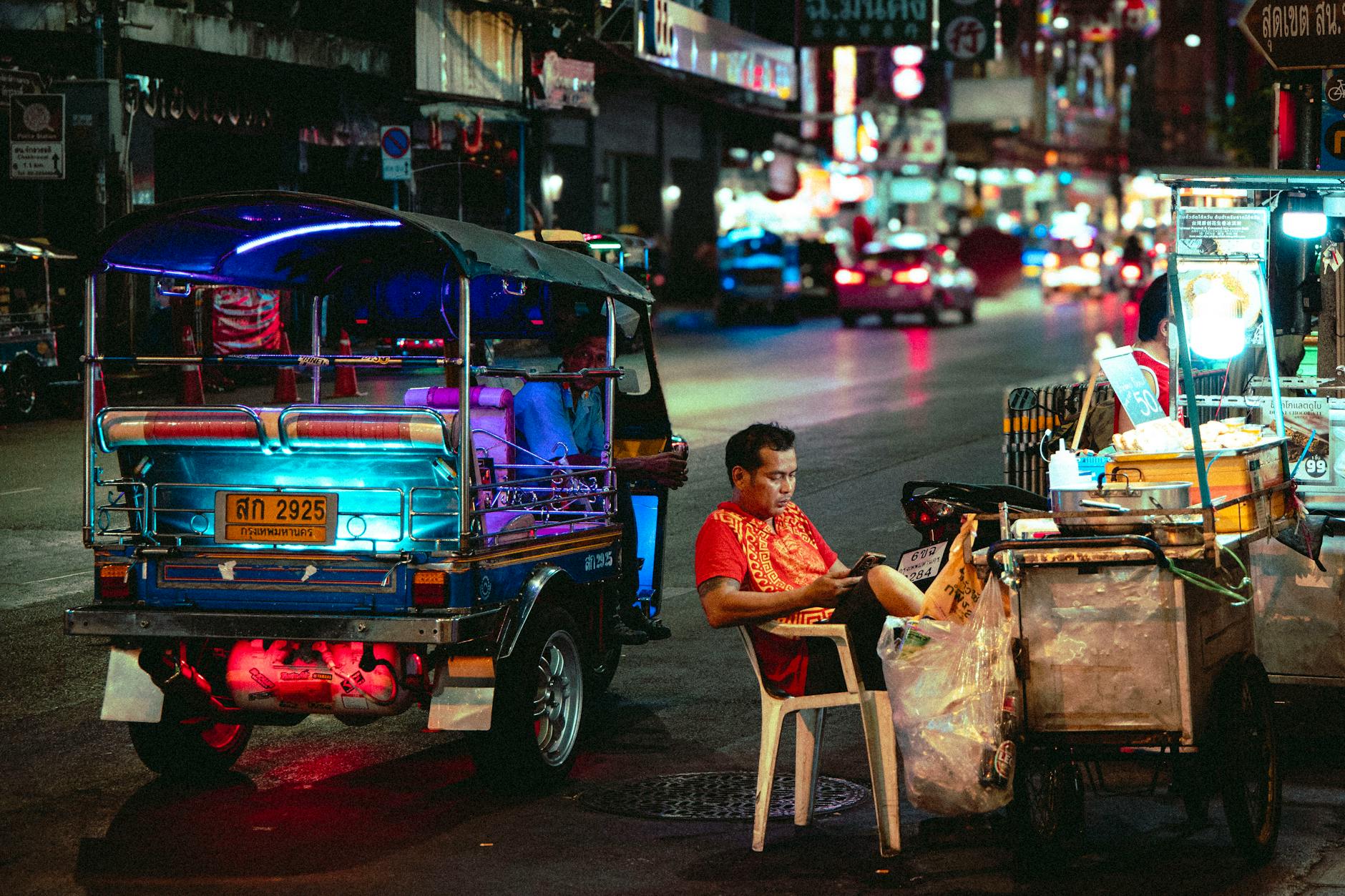 vibrant night street with tuk tuk in thailand