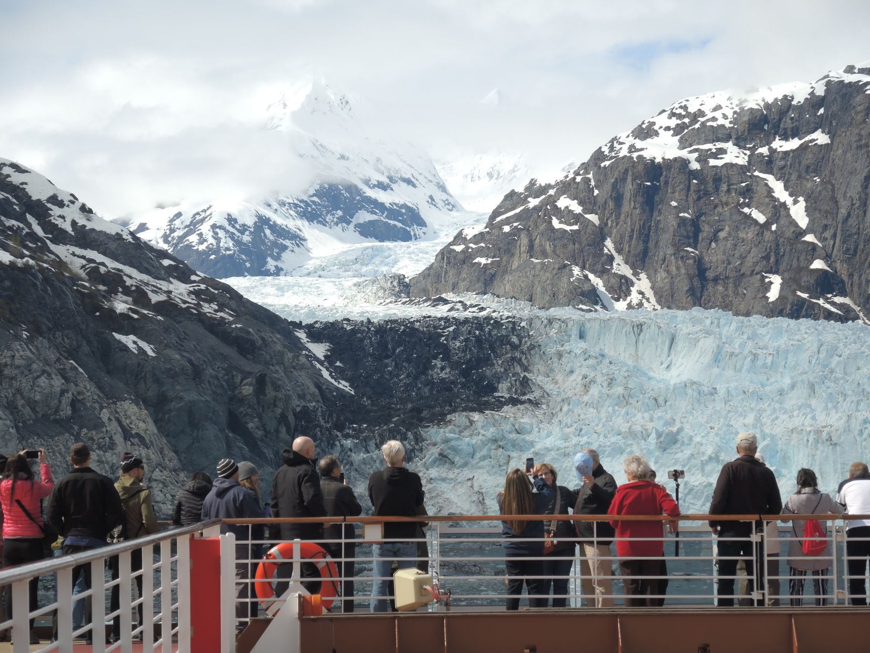 tourists viewing majestic glacier from cruise ship deck