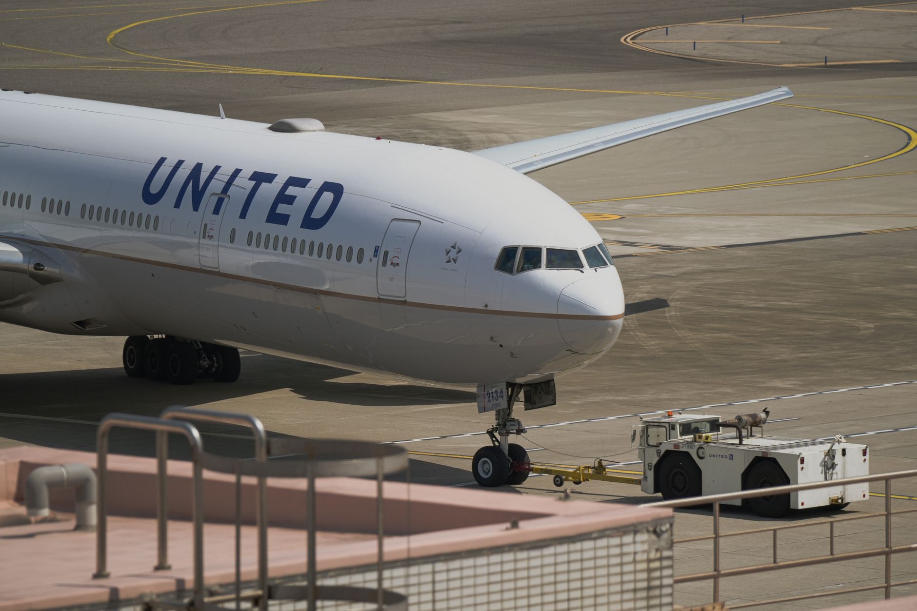 united airline plane being towed on runway