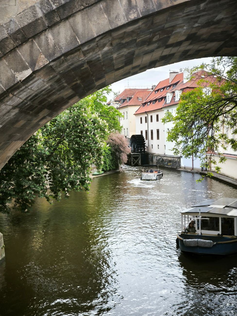 scenic river view with boats under stone bridge