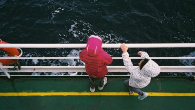 children observing ocean from boat deck