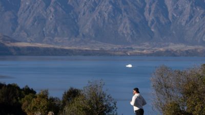 jogger in scenic landscape of queenstown new zealand