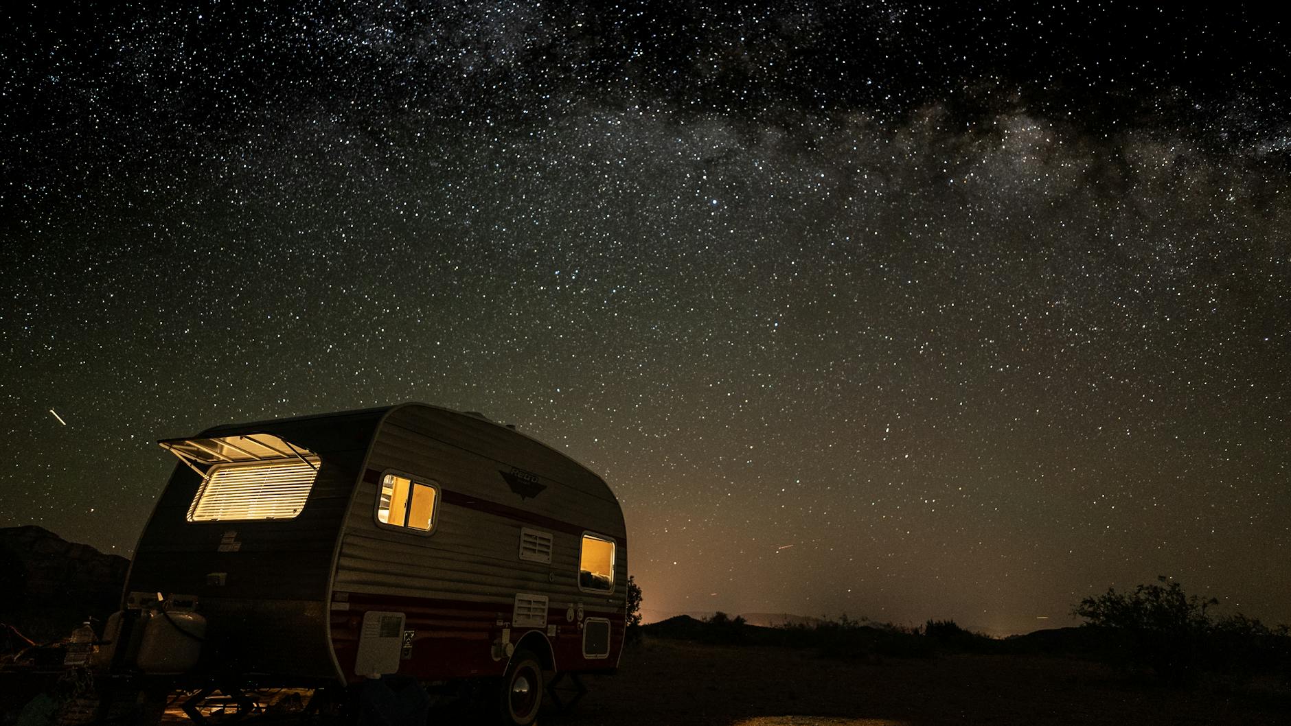 starry night sky above vintage camper