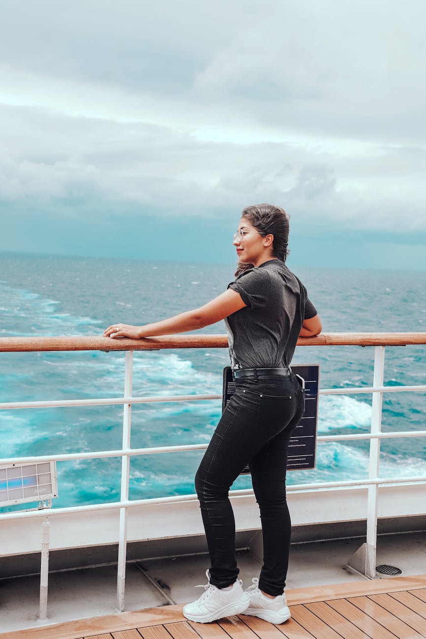 woman standing on ship overlooking body of water