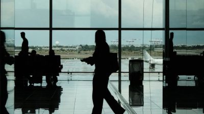 silhouetted travelers in barcelona airport terminal