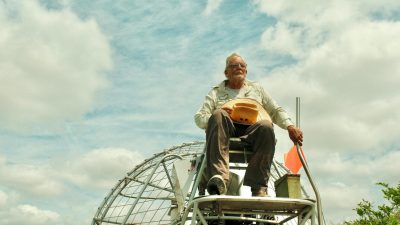 senior man on airboat exploring the florida everglades