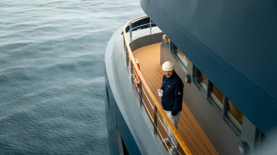 man on yacht deck with coffee at sea