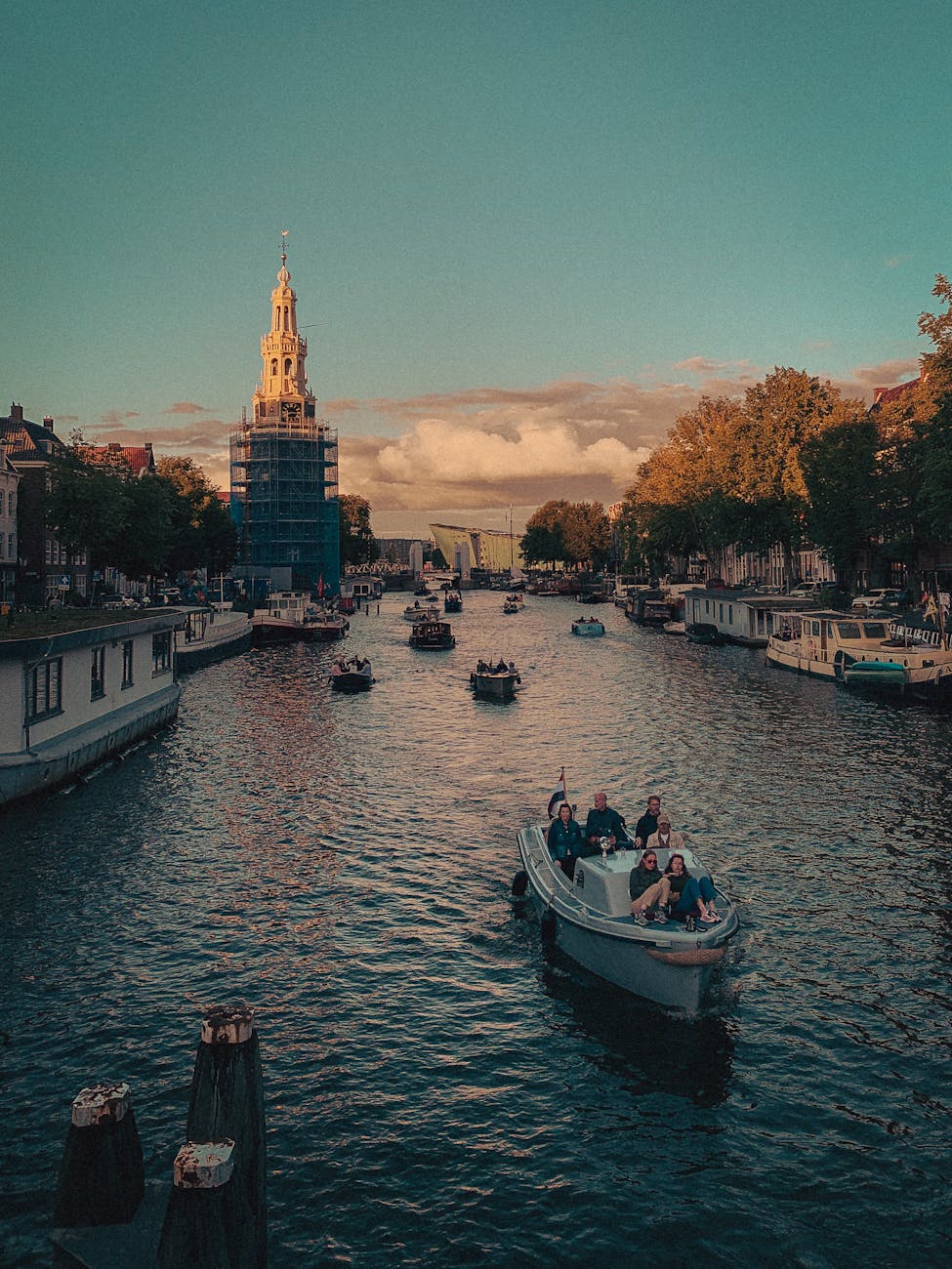 scenic amsterdam canal with boats at sunset