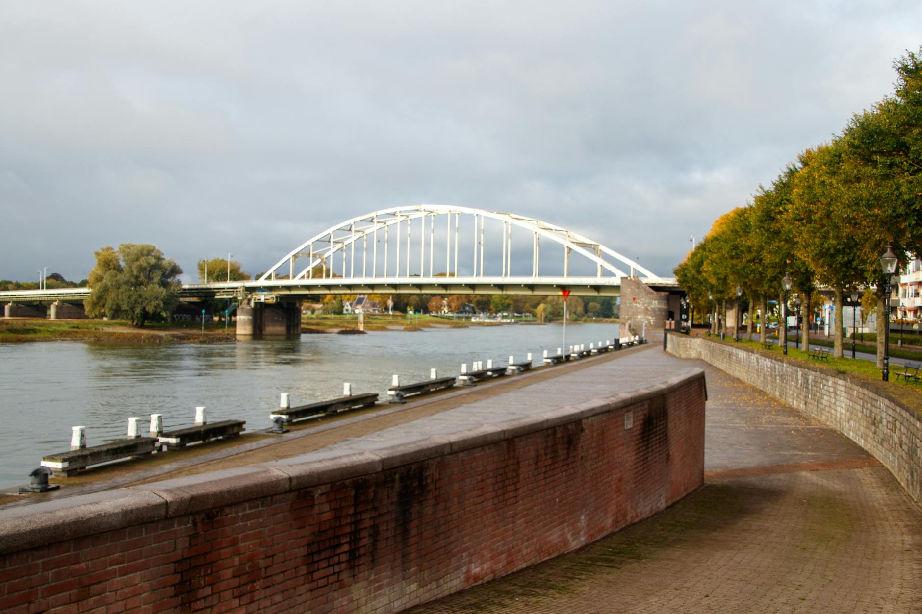 sunny riverside view of iconic bridge at arnhem