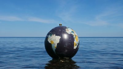 globe floating on ocean water under blue sky