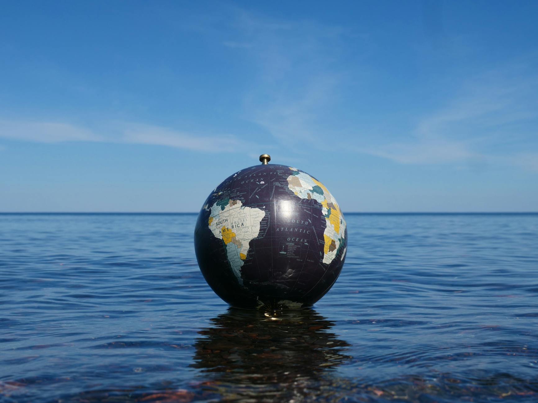 globe floating on ocean water under blue sky