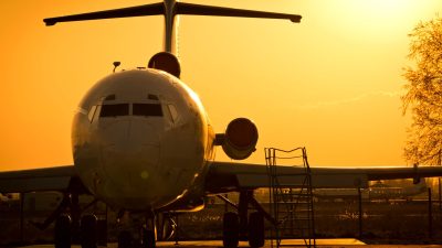 commercial airplane parked at sunset