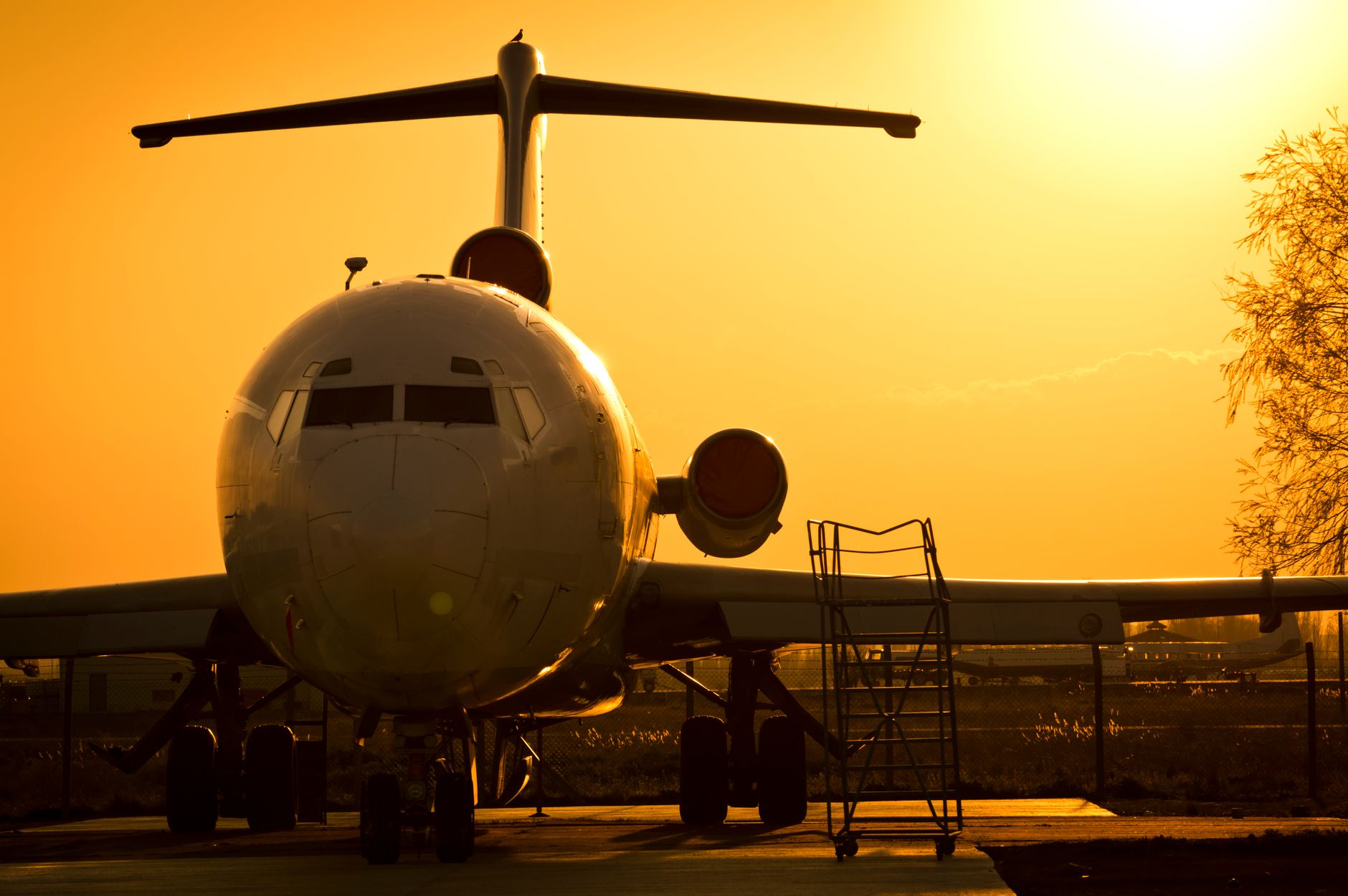 commercial airplane parked at sunset