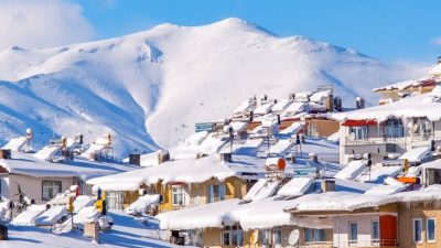 ski town in snow mountains under clear blue sky