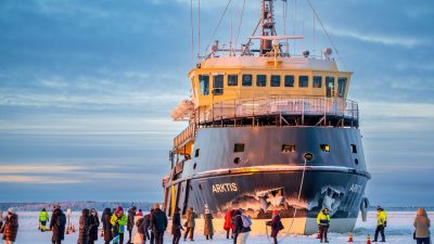 icebreaker ship docked on frozen sea with tourists