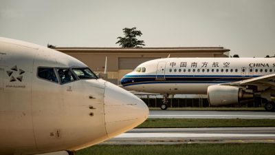 commercial airplanes on airport runway at sunset