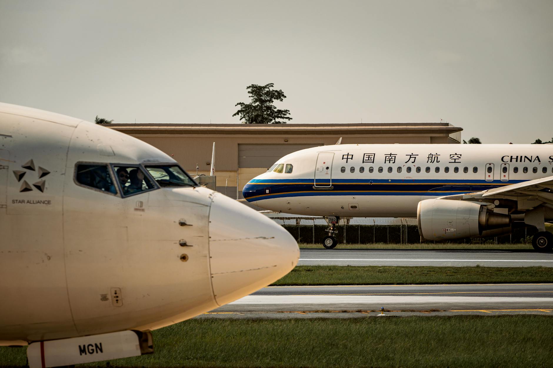 commercial airplanes on airport runway at sunset