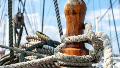 close up of nautical ropes and wooden cleat