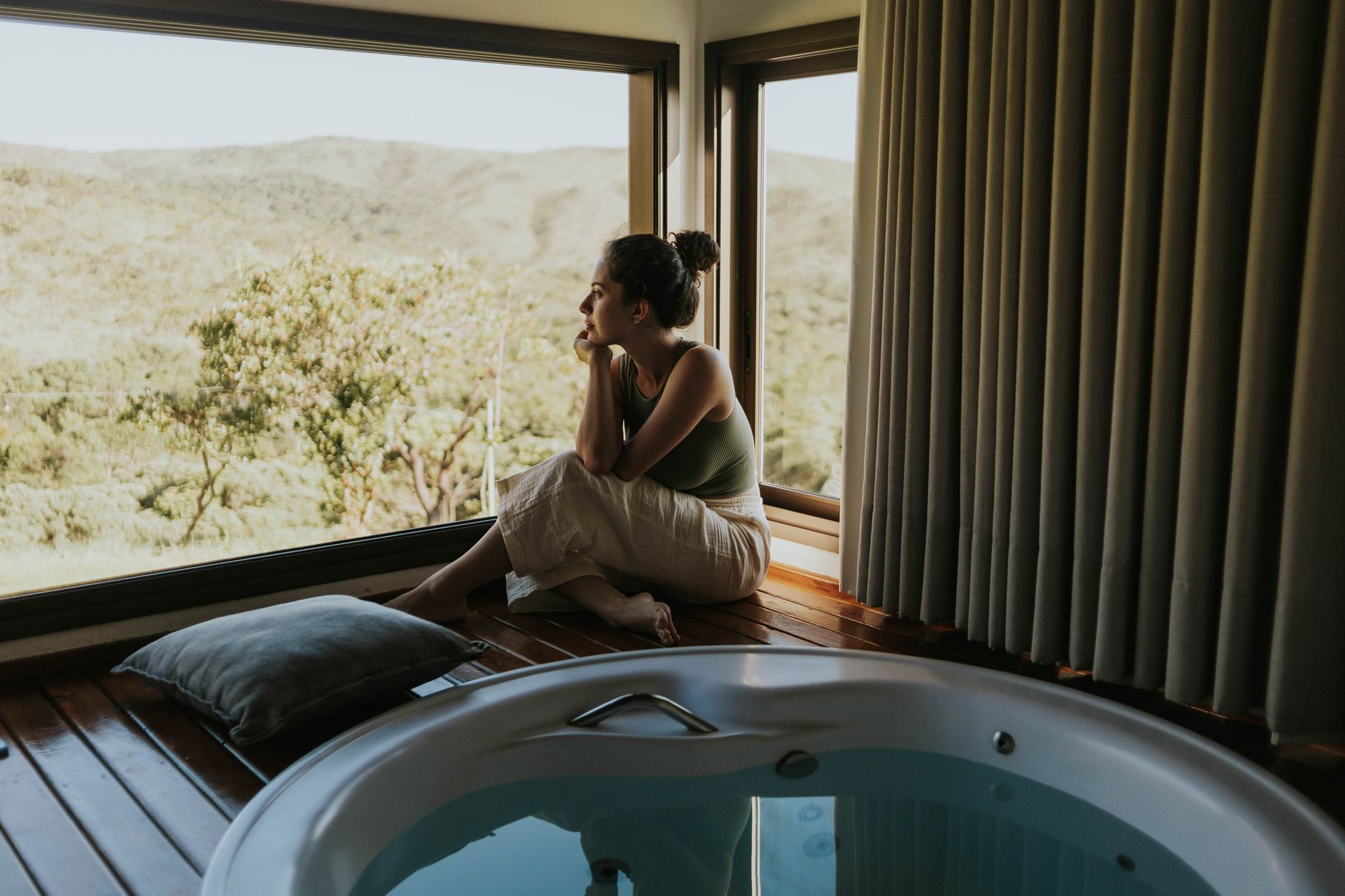 contemplative woman by jacuzzi with scenic view