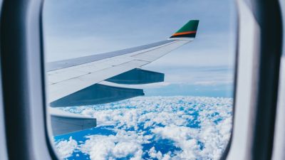 airplane window view of airplane wing and clouds