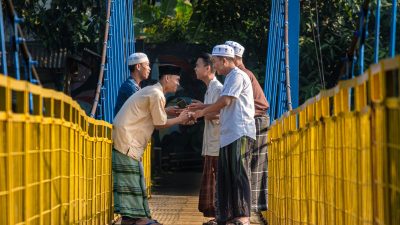 traditional greeting on indonesian suspension bridge