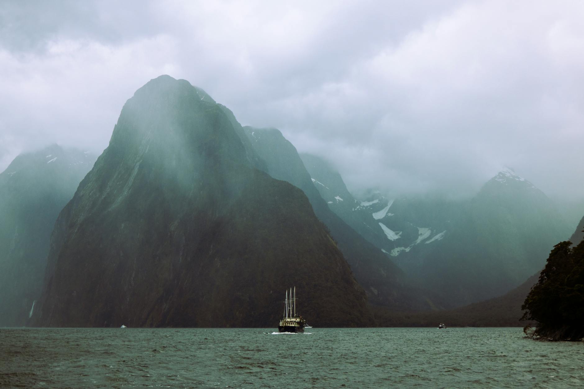 dramatic view of milford sound with sailboat
