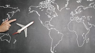 airplane over world map on blackboard
