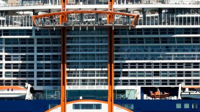 modern cruise ship docked by urban skyline