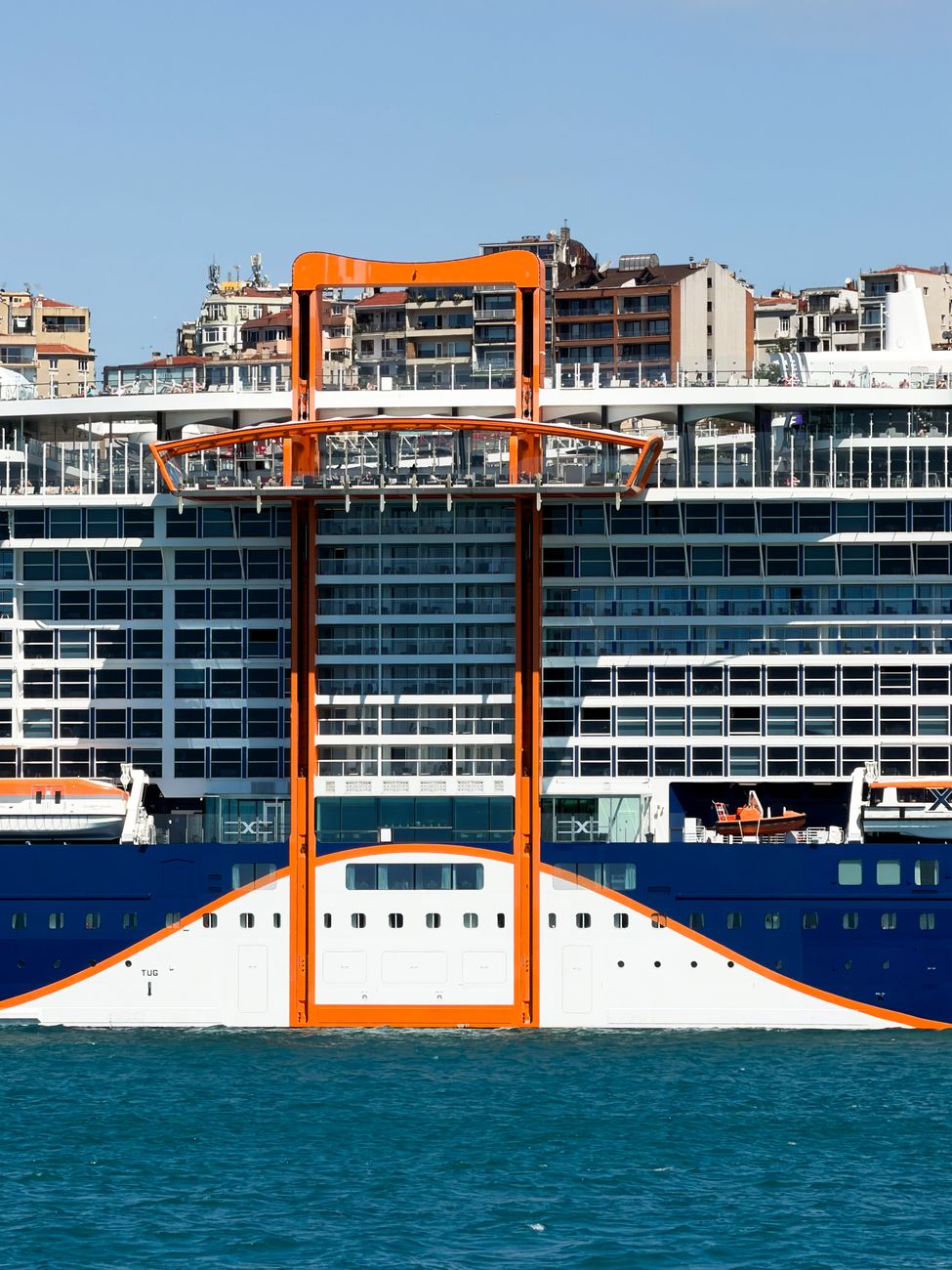 modern cruise ship docked by urban skyline