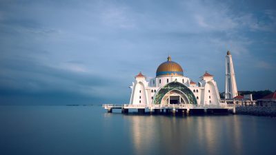 white and brown mosque beside body of water