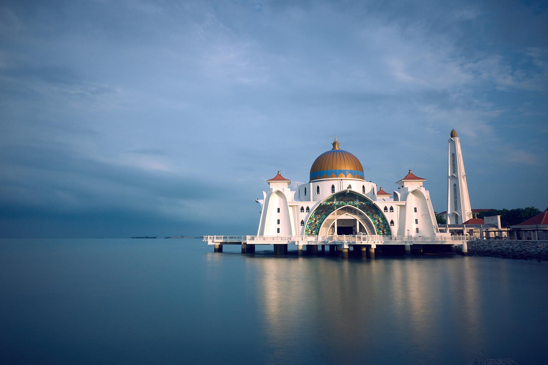 white and brown mosque beside body of water