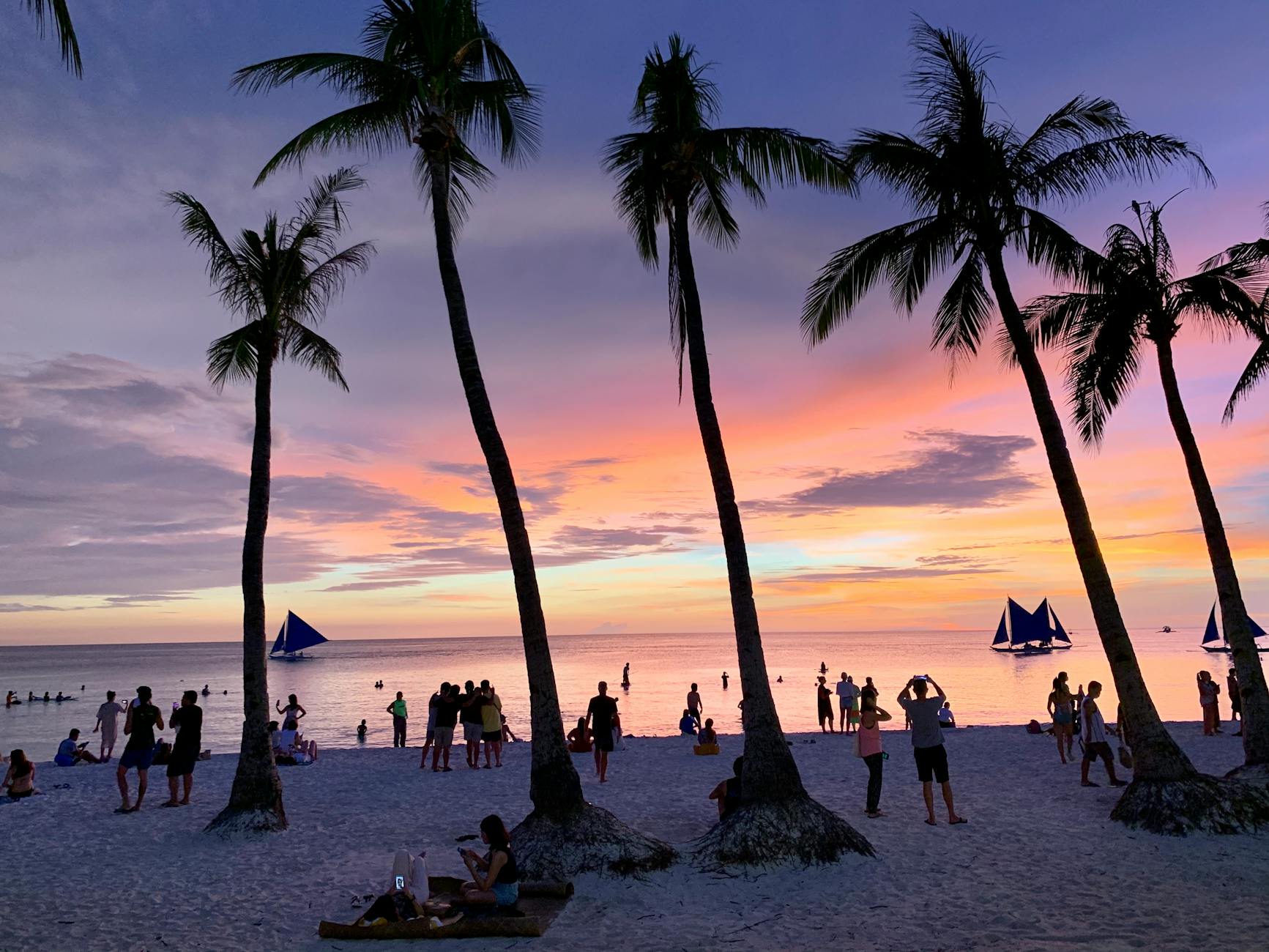 crowd on beach at sunset