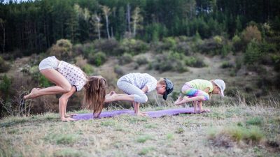 a family doing yoga on a grass field