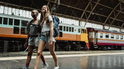 women with backpacks on train station