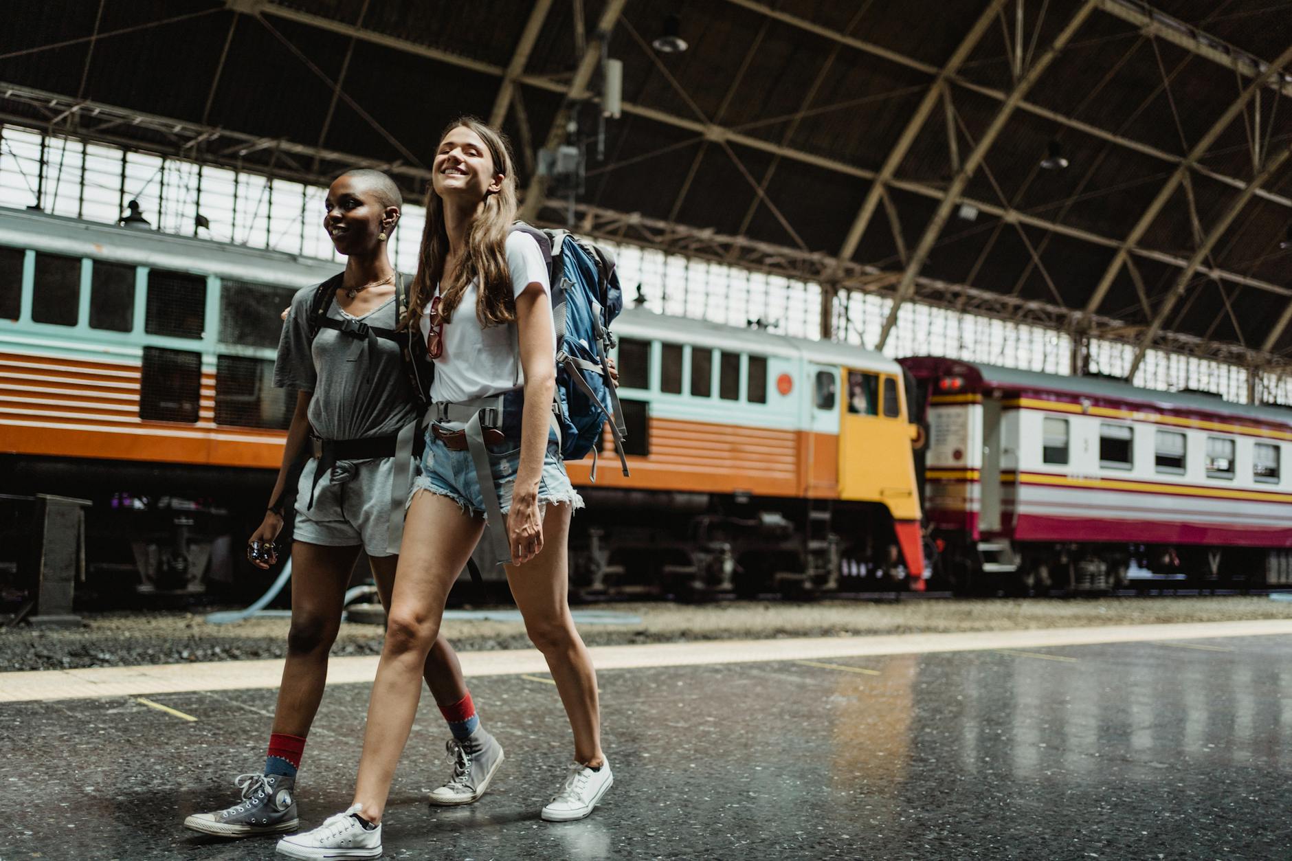 women with backpacks on train station
